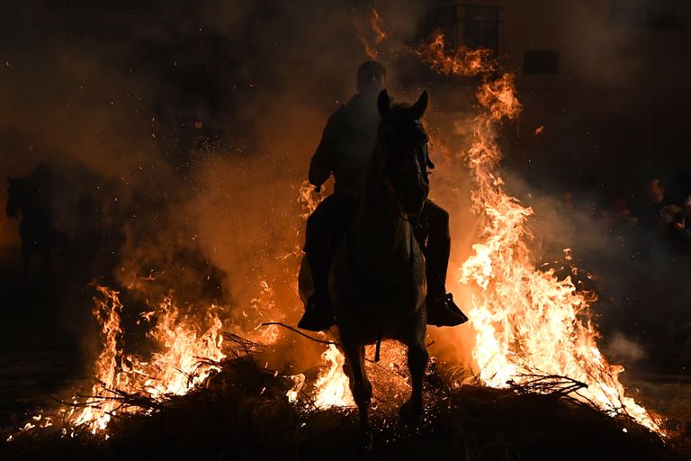 Всадник прыгает через костер во время огненного фестиваля Las Luminarias в Испании Всадник прыгает через костер во время огненного фестиваля Las Luminarias в Испании