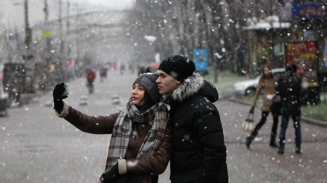 Молодые люди во время снегопада в Киеве Молодые люди во время снегопада в Киеве