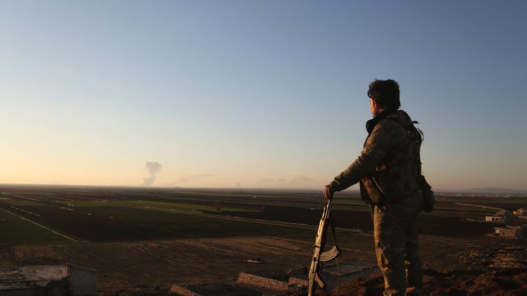 Сирийский боец наблюдает за районом Африна Сирийский боец наблюдает за районом Африна