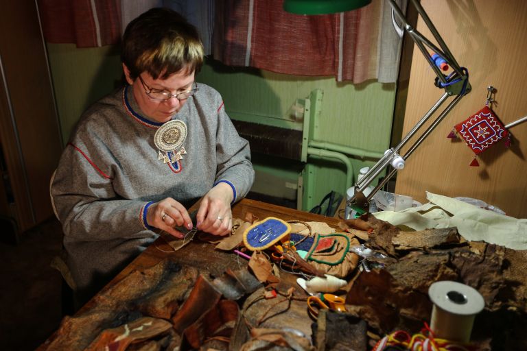 Женщина во время изготовления изделий из рыбьей кожи в поселке при железнодорожной станции Лопарская в Кольском районе Мурманской области