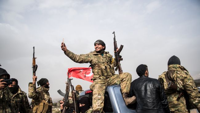 Боец сирийской оппозиции фоторафирует колонну турецких солдат около сирийской границы. Архивное фото Боец сирийской оппозиции фоторафирует колонну турецких солдат около сирийской границы. Архивное фото