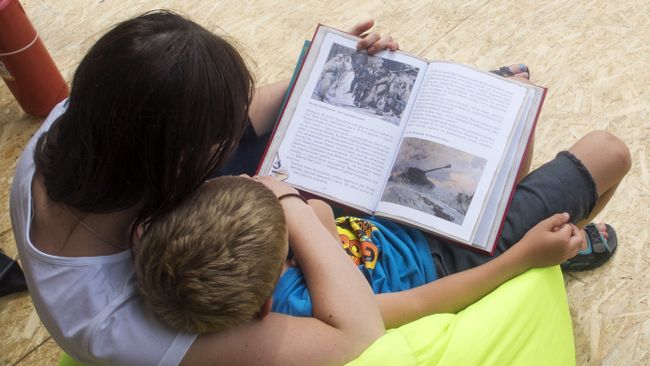 Женщина и ребенок читают книгу. Архивное фото