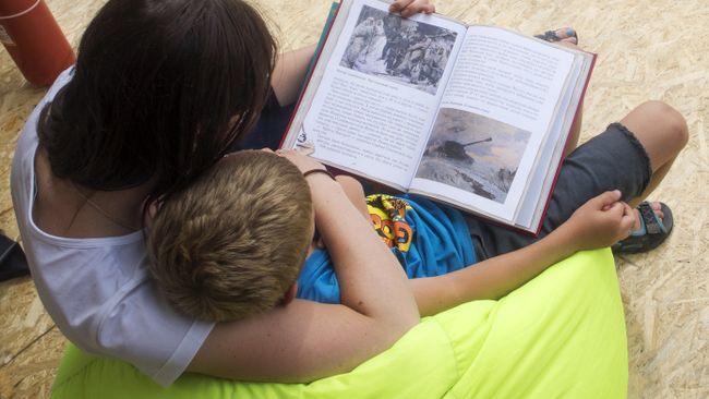 Женщина и ребенок читают книгу на одной из площадок Московского фестиваля Книги России на Красной площади Женщина и ребенок читают книгу на одной из площадок Московского фестиваля Книги России на Красной площади