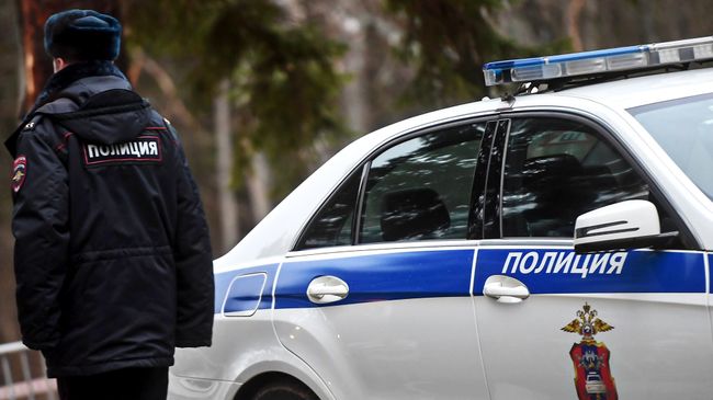 Сотрудник полиции возле служебного автомобиля. Архивное фото Сотрудник полиции возле служебного автомобиля. Архивное фото