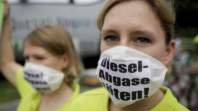 Протестующие в масках с надписью Kill diesel emissions в Берлине. Архивное фото Протестующие в масках с надписью Kill diesel emissions в Берлине. Архивное фото