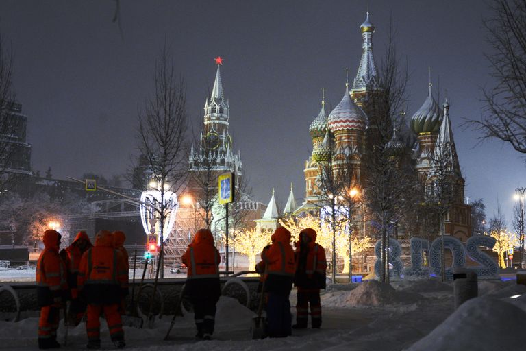 Сотрудники коммунальных служб убирают снег на улице в Москве