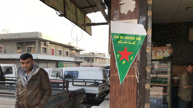Флаг курдских сил самообороны (YPJ) на центральной улице города Африн, Сирия. Архивное фото Флаг курдских сил самообороны (YPJ) на центральной улице города Африн, Сирия. Архивное фото