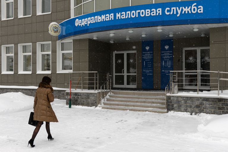 Женщина у входа в здание инспекции Федеральной налоговой службы РФ в Новосибирске