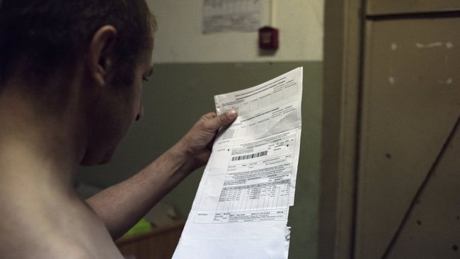 Мужчина держит квитанцию оплаты коммунальных услуг Мужчина держит квитанцию оплаты коммунальных услуг