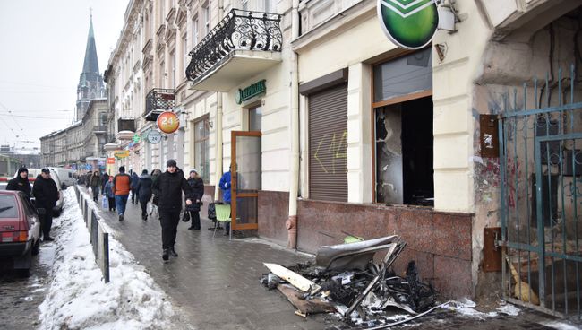 Прохожие на улице у отделения Сбербанка во Львове, подожженного радикалами. 14 февраля 2018 Прохожие на улице у отделения Сбербанка во Львове, подожженного радикалами. 14 февраля 2018