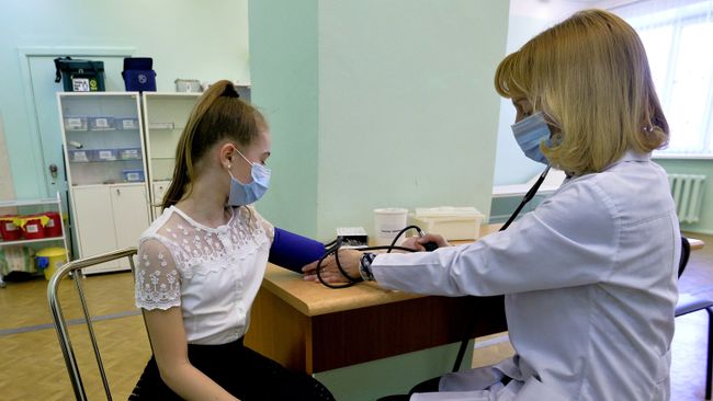 Врач осматривает пациента в целях профилактики заболевания гриппом и ОРВИ. Архивное фото Врач осматривает пациента в целях профилактики заболевания гриппом и ОРВИ. Архивное фото