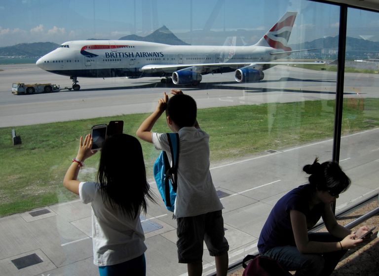 Пассажиры фотографируют Боинг 747 авиакомпании British Airways в международном аэропорту Гонконга Пассажиры фотографируют Боинг 747 авиакомпании British Airways в международном аэропорту Гонконга