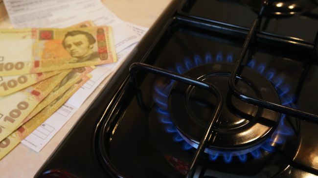 Горящая газовая конфорка и денежные купюры Украины Горящая газовая конфорка и денежные купюры Украины