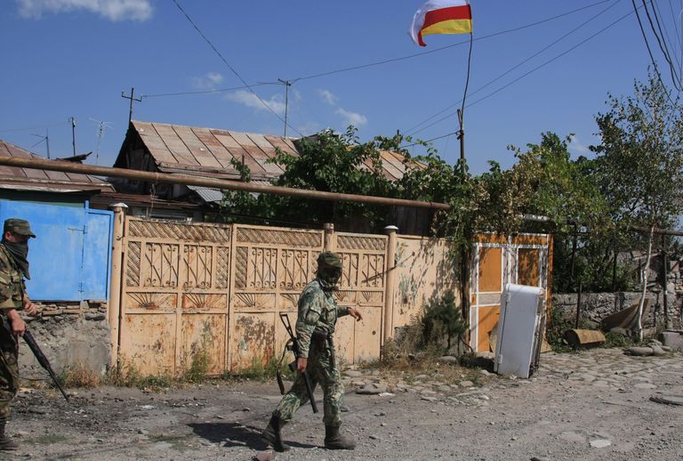 Российские военнослужащие и югоосетинские ополченцы в городе Цхинвали, подвергшемся нападению грузинских войс