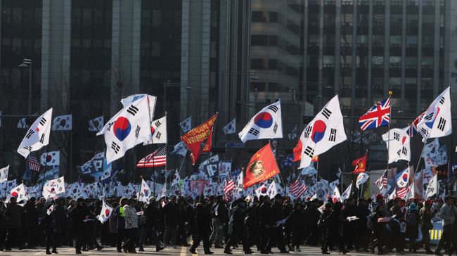 Участники митинга с флагами Южной Кореи, США, Великобритании на одной из улиц в Сеуле Участники митинга с флагами Южной Кореи, США, Великобритании на одной из улиц в Сеуле