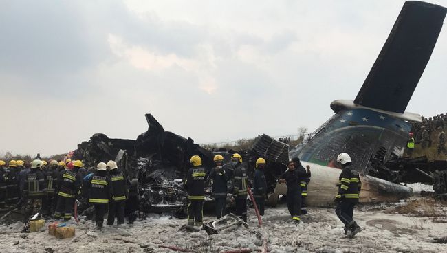 Спасатели на месте крушения самолета авиакомпании US-Bangla Airlines в Катманду, Непал. 12 марта 2018