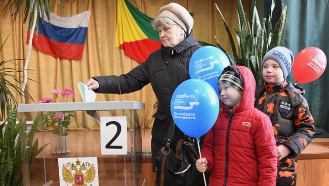 Женщина опускает бюллетень в урну на выборах президента Российской Федерации на избирательном участке в Чите. 18 марта 2018 Женщина опускает бюллетень в урну на выборах президента Российской Федерации на избирательном участке в Чите. 18 марта 2018