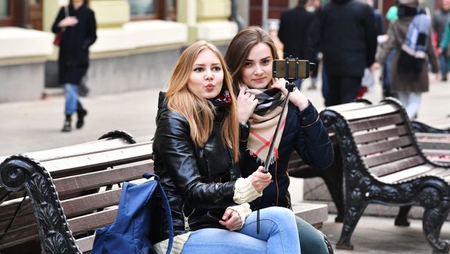 Девушки фотографируются на Никольской улице в Москве. Девушки фотографируются на Никольской улице в Москве.
