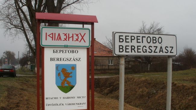Надпись на украинском и венгерском языках на знаке при въезде в город Берегово в Закарпатской области Украины. Архивное фото Надпись на украинском и венгерском языках на знаке при въезде в город Берегово в Закарпатской области Украины. Архивное фото