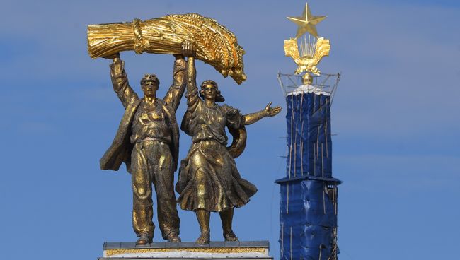 Скульптура Тракторист и колхозница на арке Главного входа ВДНХ. Архивное фото Скульптура Тракторист и колхозница на арке Главного входа ВДНХ. Архивное фото