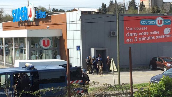 Сотрудники полиции у супермаркета Super U в коммуне Треб на юге Франции, где произошел захват заложников. 23 марта 2018 Сотрудники полиции у супермаркета Super U в коммуне Треб на юге Франции, где произошел захват заложников. 23 марта 2018