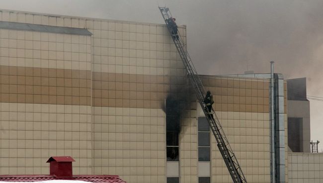Сотрудники пожарной охраны МЧС борются с пожаром в торговом центре «Зимняя вишня» в Кемерово. 25 марта 2018 Сотрудники пожарной охраны МЧС борются с пожаром в торговом центре «Зимняя вишня» в Кемерово. 25 марта 2018