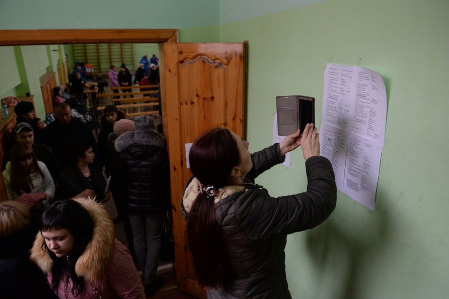 Женщина фотографирует на мобильный телефон списки пропавших без вести при пожаре в торговом центре Зимняя вишня в Кемерово Женщина фотографирует на мобильный телефон списки пропавших без вести при пожаре в торговом центре Зимняя вишня в Кемерово