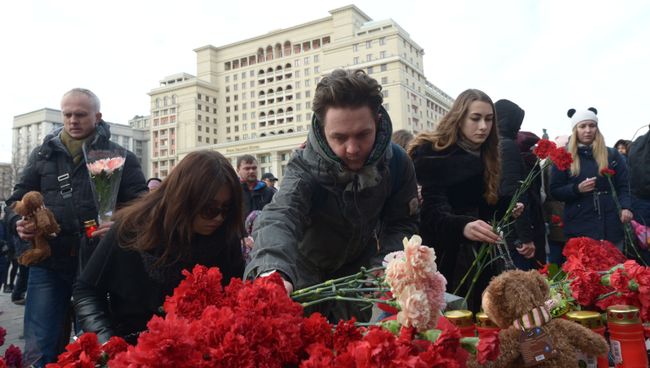 Люди возлагают цветы к мемориалу на Манежной площади в Москве в память о погибших в кемеровском торговом центре Зимняя вишня. Архивное фото Люди возлагают цветы к мемориалу на Манежной площади в Москве в память о погибших в кемеровском торговом центре Зимняя вишня. Архивное фото