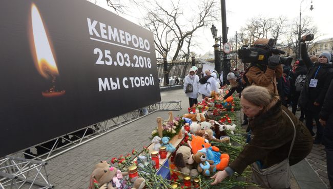 Люди возлагают цветы к мемориалу на Манежной площади в Москве в память о погибших в кемеровском торговом центре Зимняя вишня Люди возлагают цветы к мемориалу на Манежной площади в Москве в память о погибших в кемеровском торговом центре Зимняя вишня