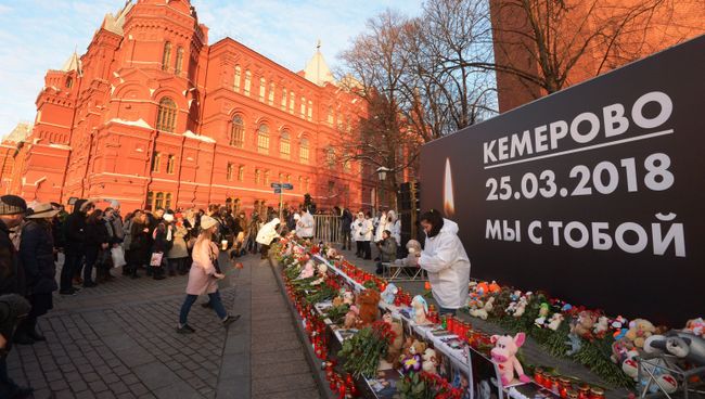 Люди возлагают цветы к мемориалу на Манежной площади в Москве в память о погибших в кемеровском торговом центре Зимняя вишня Люди возлагают цветы к мемориалу на Манежной площади в Москве в память о погибших в кемеровском торговом центре Зимняя вишня