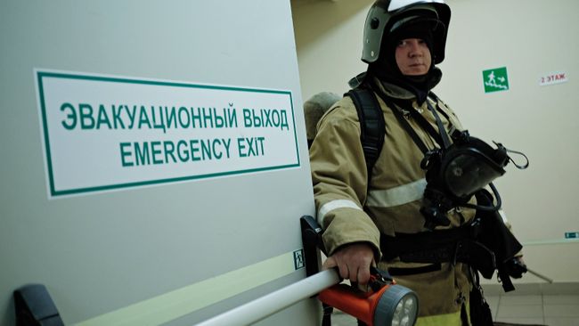 Сотрудник противопожарной службы у эвакуационного выхода во время учений в торговом центре Галерея Краснодар