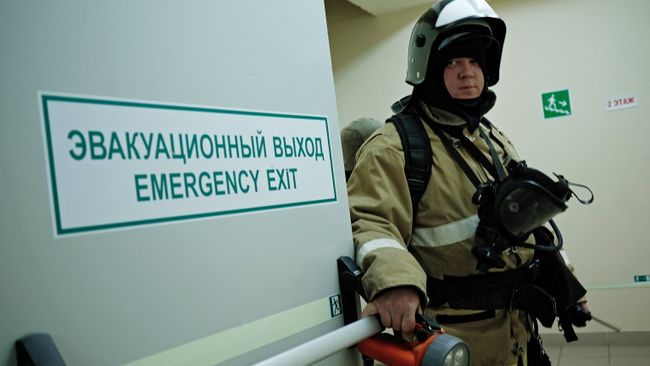 Сотрудник противопожарной службы у эвакуационного выхода. Архивное фото Сотрудник противопожарной службы у эвакуационного выхода. Архивное фото