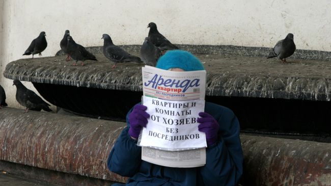 Женщина держит в руках газету Аренда квартир