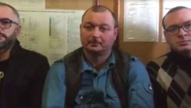 Капитан задержанного в Бердянске судна Норд Владимир Горбенко с адвокатами на стоп-кадре видеозаписи обращения, распространенного в социальных сетях Капитан задержанного в Бердянске судна Норд Владимир Горбенко с адвокатами на стоп-кадре видеозаписи обращения, распространенного в социальных сетях