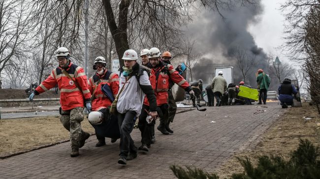 Сторонники оппозиции несут раненного за баррикады на площади Независимости в Киеве Сторонники оппозиции несут раненного за баррикады на площади Независимости в Киеве