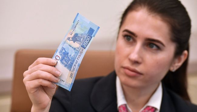 Девушка с купюрой 2000 рублей. Архивное фото Девушка с купюрой 2000 рублей. Архивное фото
