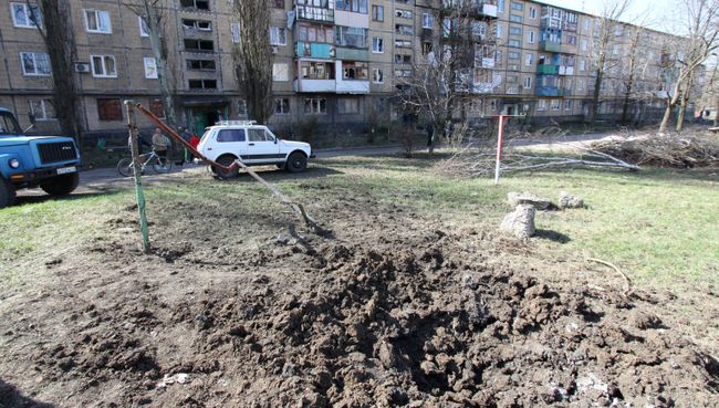 Воронка от снаряда во дворе жилого дома после ночного обстрела в Донецке. Архивное фото Воронка от снаряда во дворе жилого дома после ночного обстрела в Донецке. Архивное фото