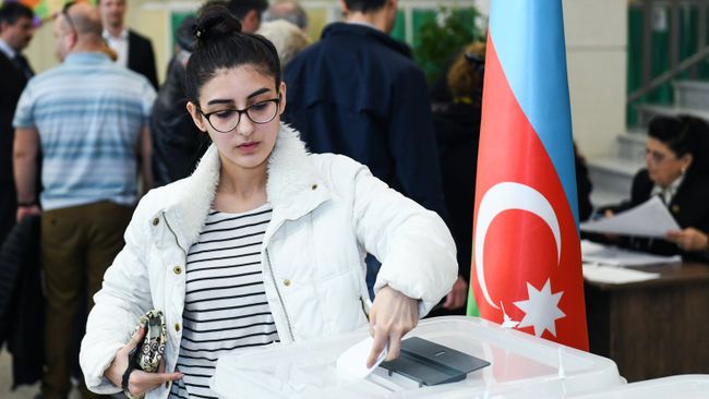 Девушка голосует на выборах президента Азербайджана на избирательном участке в Баку