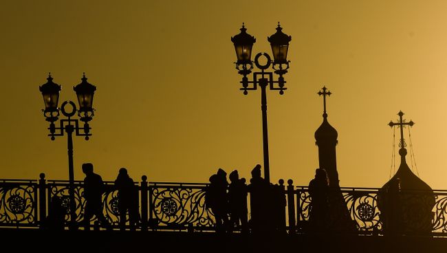 Прохожие на Патриаршем мосту в Москве Прохожие на Патриаршем мосту в Москве