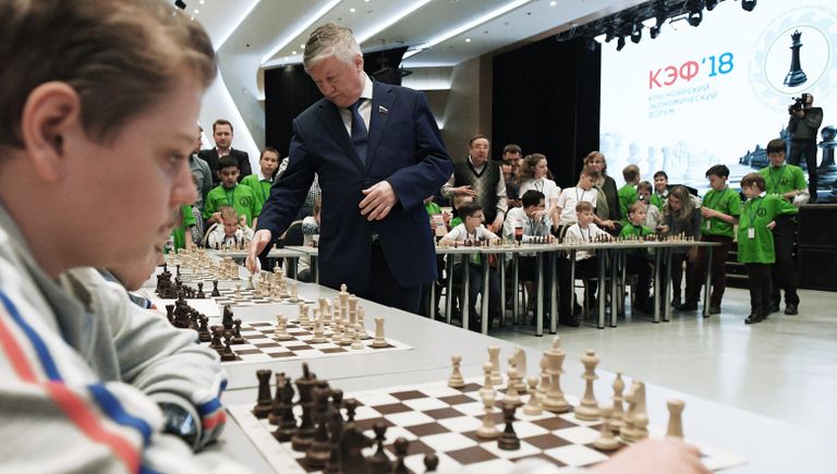 Двенадцатый чемпион мира по шахматам Анатолий Карпов (в центре) во время сеанса одновременной игры на открытом шахматном фестивале в рамках Красноярского экономического форума