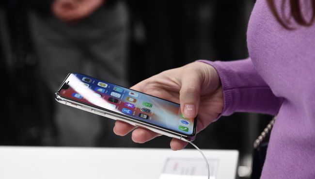 Покупательница рассматривает новый смартфон iPhone X. Архивное фото Покупательница рассматривает новый смартфон iPhone X. Архивное фото