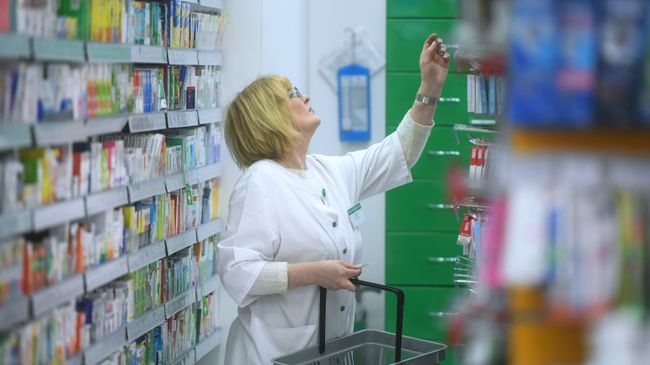 Фармацевт раскладывает лекарственные препараты Фармацевт раскладывает лекарственные препараты