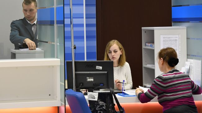 Сотрудники помогают посетительнице со сдачей налоговой отчетности в день открытых дверей в операционном зале инспекции Федеральной налоговой службы РФ в Москве