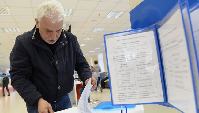 Посетитель заполняет документы в операционном зале инспекции Федеральной налоговой службы РФ в Москве. Архивное фото Посетитель заполняет документы в операционном зале инспекции Федеральной налоговой службы РФ в Москве. Архивное фото