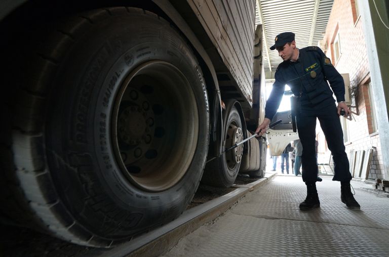 Сотрудник пограничной службы во время осмотра большегрузного автомобиля на многостороннем автомобильном пункте пропуска Пограничный в Приморском крае на российско-китайской границе Сотрудник пограничной службы во время осмотра большегрузного автомобиля на многостороннем автомобильном пункте пропуска Пограничный в Приморском крае на российско-китайской границе
