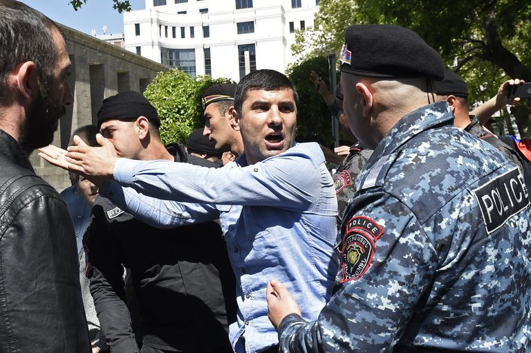 Мужчина и сотрудник правоохранительных органов на улице в Ереване. 25 апреля 2018