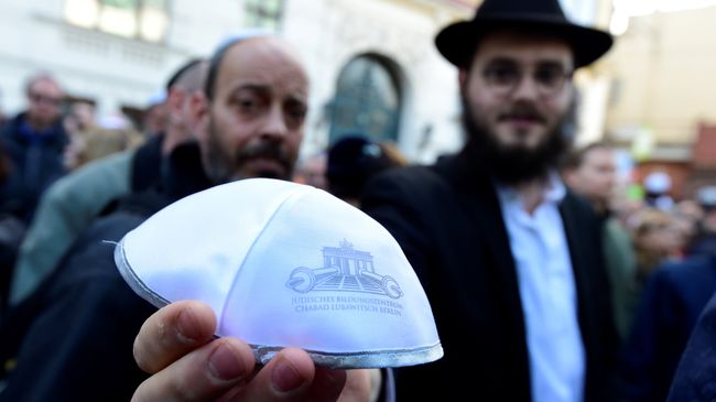 Мужчина показывает традиционную еврейскую кипу на мероприятии Berlin wears kippa в Берлине Мужчина показывает традиционную еврейскую кипу на мероприятии Berlin wears kippa в Берлине