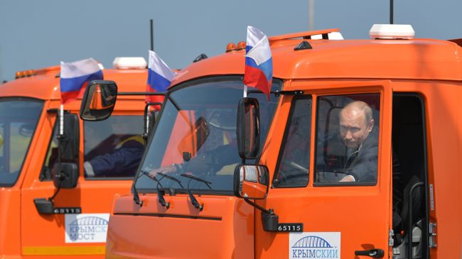 Президент РФ Владимир Путин садится за руль автомобиля КамАЗ во время проезда колонны строительной техники по автодорожной части Крымского моста. 15 мая 2018 Президент РФ Владимир Путин садится за руль автомобиля КамАЗ во время проезда колонны строительной техники по автодорожной части Крымского моста. 15 мая 2018