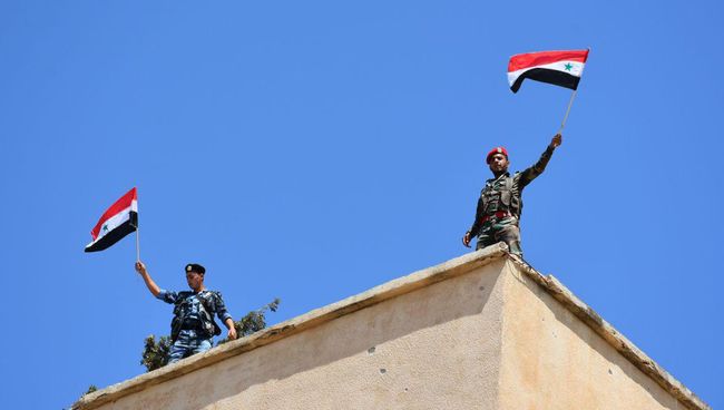 Сирийские военные с флагами в освобожденном от боевиков населенном пункте в провинции Хомс. Архивное фото Сирийские военные с флагами в освобожденном от боевиков населенном пункте в провинции Хомс. Архивное фото