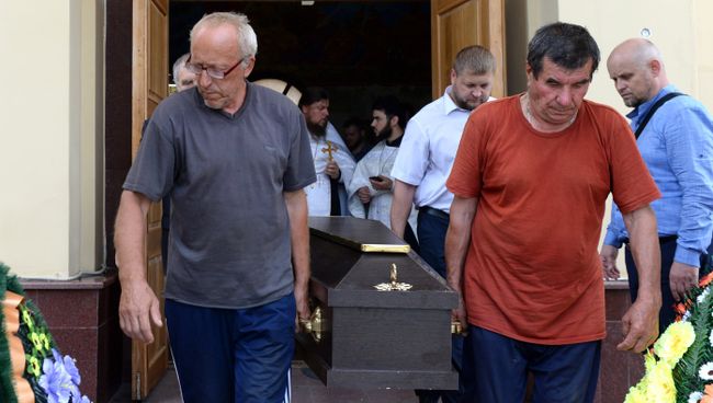 Люди выносят гроб с телом прихожанина Артемия, погибшего при нападении на храм Архангела Михаила в Грозном. 22 мая 2018